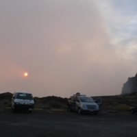 Volcan Masaya at Sunset, volcano spewing gases beyond the parking lot